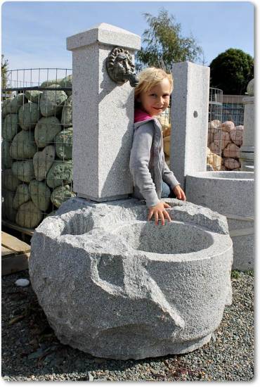 Das ist ein Gartenbrunnen mit seitlichen Pflanzmulden aus Granit für den Garten.
