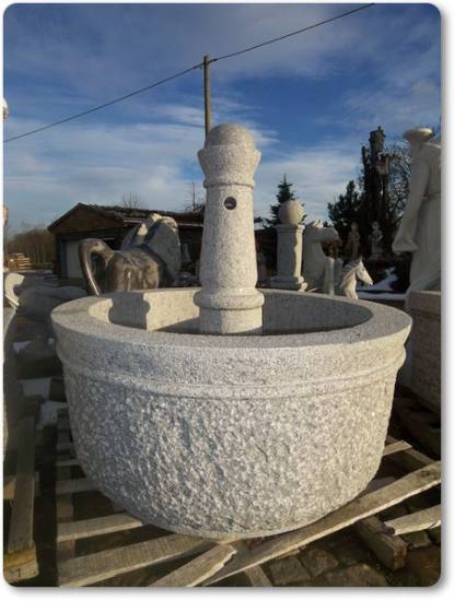 Das ist ein goßer Gartenbrunnen aus aus grauen Granit. Der Brunnen hat in der Mitte eine Säule.