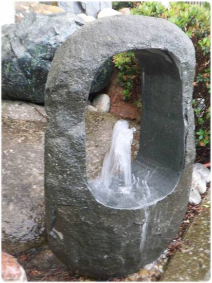 Das ist ein Springbrunnen aus einem Natursteinfindling.